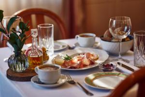 a table with plates of food and wine glasses at Hotel Lovran in Lovran