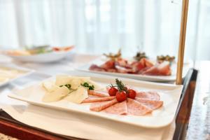 a plate of meats and cheese on a table at Hotel Lovran in Lovran
