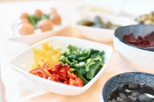 a white bowl filled with vegetables and other foods at Hotel Lovran in Lovran