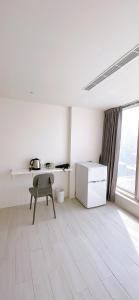 Dieses weiße Zimmer verfügt über einen Schreibtisch und einen Stuhl. in der Unterkunft 三弄旅宿3rd Alley Inn in Kaohsiung