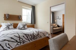 a bedroom with a bed with a black and white comforter at Hotel Jagdhof in Filzmoos