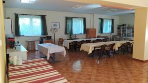 a dining room with tables and chairs and windows at Dom Gościnny Koinonia in Mrągowo
