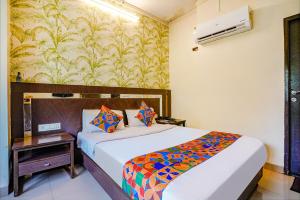 a bedroom with a bed and a wall mural at FabHotel Gargi Deluxe in Pune