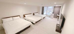ein Hotelzimmer mit 2 Betten und einem Flachbild-TV in der Unterkunft 三弄旅宿3rd Alley Inn in Kaohsiung