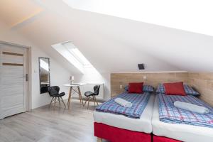 アウグストゥフにあるCity Center Apartments Mostowa 17Aのベッド2台とテーブルと椅子のある寝室