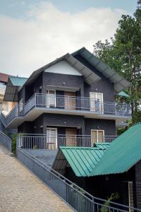 a house with a green roof on a street at Ramee Wolkenburg Resort & Spa, Munnar in Munnar