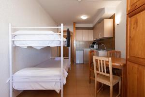 een kamer met 2 stapelbedden en een keuken bij Estudis Turístics Cims Pas 3000 in Pas de la Casa