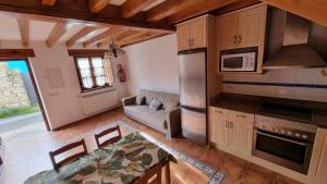 a kitchen and living room with a couch and a table at Apartamento Casa Male in Pimiango +24 photos