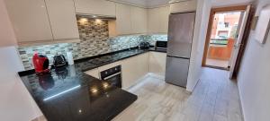 Kuchyňa alebo kuchynka v ubytovaní Homes of Spain, Apartamentos Paraíso, Ed Palmerston, Atico B a pie de Playa, piscina privada en solárium, WI-FI
