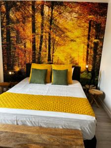 a bedroom with a bed with a painting of trees at Chez Monsieur le directeur de la poste in Piégut-Pluviers