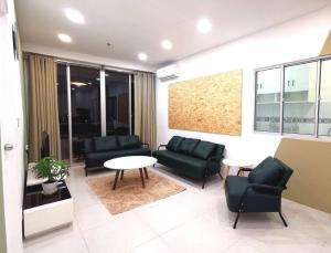 uma sala de estar com um sofá, cadeiras e uma mesa em Wincy Home Metrocity Kuching-N em Kuching