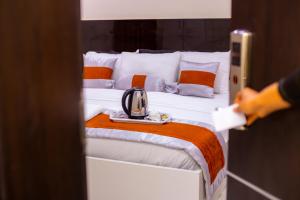 a person is looking at a bed with a tea kettle on it at Appleville Suites in Ikeja