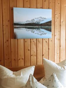 a picture of a lake with snow capped mountains on a wooden wall at Alpenappartements Schwalbennestl in Mittenwald
