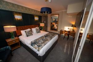 a bedroom with a large bed and a table and chairs at Riverside Hotel by Chef & Brewer Collection in Burton upon Trent