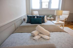 a bedroom with a bed with towels on it at V&V CENTRE Neuchatel in Neuchâtel