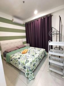 a bedroom with a bed and a purple curtain at Wincy Home Metrocity Kuching-N in Kuching