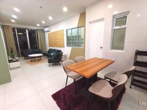 a living room with a wooden table and chairs at Wincy Home Metrocity Kuching-N in Kuching