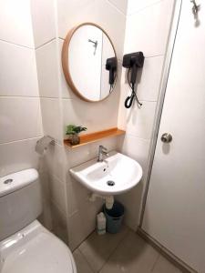 a bathroom with a toilet and a sink and a mirror at Wincy Home Metrocity Kuching-N in Kuching