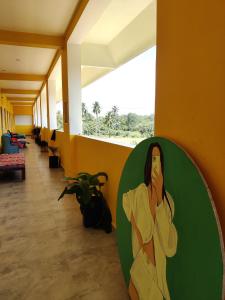 a painting of a woman on a wall in a hallway at WoodPacker Hostel Auroville Pondicherry in Auroville