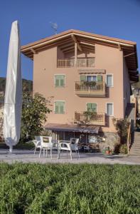 a building with tables and chairs in front of it at B&B SEGONZANO in Segonzano