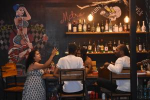 a group of people sitting at a bar at Mitra Hostel Vagator in Vagator