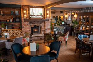 a restaurant with tables and chairs and a fireplace at Riverside Hotel by Chef & Brewer Collection in Burton upon Trent