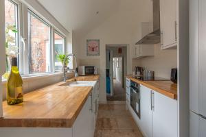 a kitchen with a bottle of wine sitting on a counter at Woodside House - 4 Bed Town House - Central Reading - Free Parking in Reading