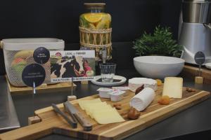 a cutting board with cheese and other ingredients on a counter at Campanile Laval Nord in Changé