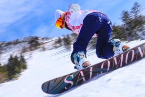 een man die op een snowboard rijdt op een sneeuw bedekte helling bij Shiga Ichii Hotel in Yamanouchi