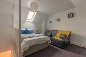 a bedroom with a bed and a couch in it at Woodside House - 4 Bed Town House - Central Reading - Free Parking in Reading