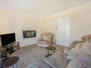 a living room with a couch and a tv at Sea View in Bognor Regis