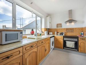 a kitchen with wooden cabinets and a large window at Sea View in Bognor Regis
