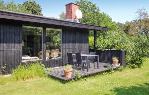 a house with a table and chairs on a deck at Stunning Home In Samsø With Wifi in Nordby