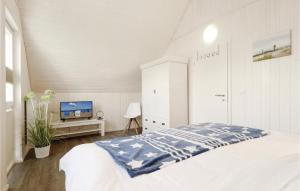 オルペニッツにあるAmazing Home In Ostseeresort Olpenitz With Kitchenの白いベッドルーム(ベッド1台、テレビ付)