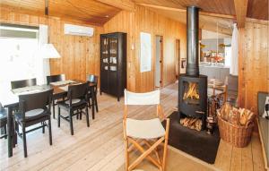 a living room with a fireplace and a table and chairs at Awesome Home In Samsø With Kitchen in Nordby