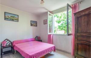 a bedroom with a pink bed and a window at Holiday Home Rue De Chardonnerets in La Crau