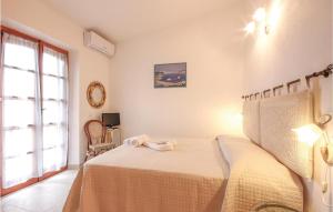 een slaapkamer met een bed met een witte sprei en een raam bij Villino Mito in San Teodoro