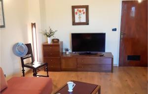 a living room with a flat screen tv and a chair at Amazing Apartment In Pula With 2 Bedrooms And Wifi in Pula