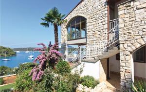 a stone house with a palm tree and a view of the water at 2 Bedroom Amazing Apartment In Pula in Pula