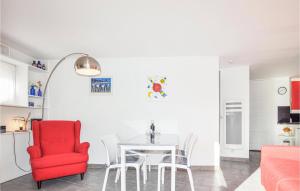 kuchnia i jadalnia z czerwonym krzesłem i stołem w obiekcie Beach Front Apartment w mieście Saint-Cyprien-Plage