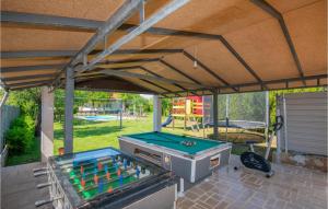 eine überdachte Terrasse mit einem Grill und einem Billardtisch in der Unterkunft Gorgeous Home In Imotski With Jacuzzi in Imotski