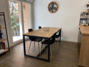 un tavolo in legno con sedie nere in cucina di Le Parc a Bergerac