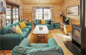uma sala de estar com sofás azuis e uma televisão em 3 Bedroom Stunning Home In Sams em Onsbjerg