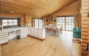 a kitchen and dining room in a log cabin at 3 Bedroom Stunning Home In Sams in Onsbjerg