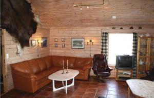 sala de estar con sofá de cuero y TV en Nice Home In Lindesnes With House Sea View, en Svenevik