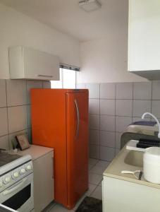 a kitchen with an orange refrigerator and a sink at Apto em condomínio , portaria 24h, com área de lazer, ideal para famílias in Imperatriz