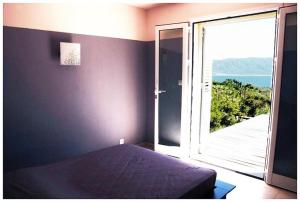 1 dormitorio con cama y ventana abierta en Résidence Ogliastrello, en Olmeto