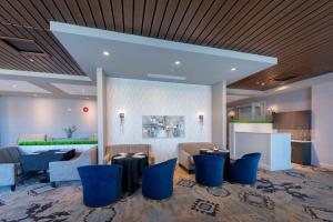 a lobby with blue chairs and a bar at Prestige Treasure Cove Resort, WorldHotels Elite in Prince George