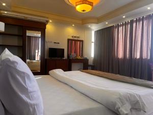 a bedroom with a large bed and a television at Oscar Hotel Petra in Wadi Musa +48 photos