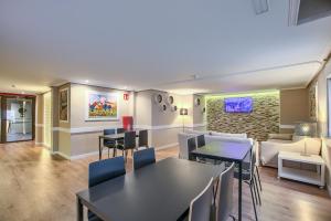 a living room with tables and chairs and a couch at HS Castilla Fuenlabrada in Fuenlabrada